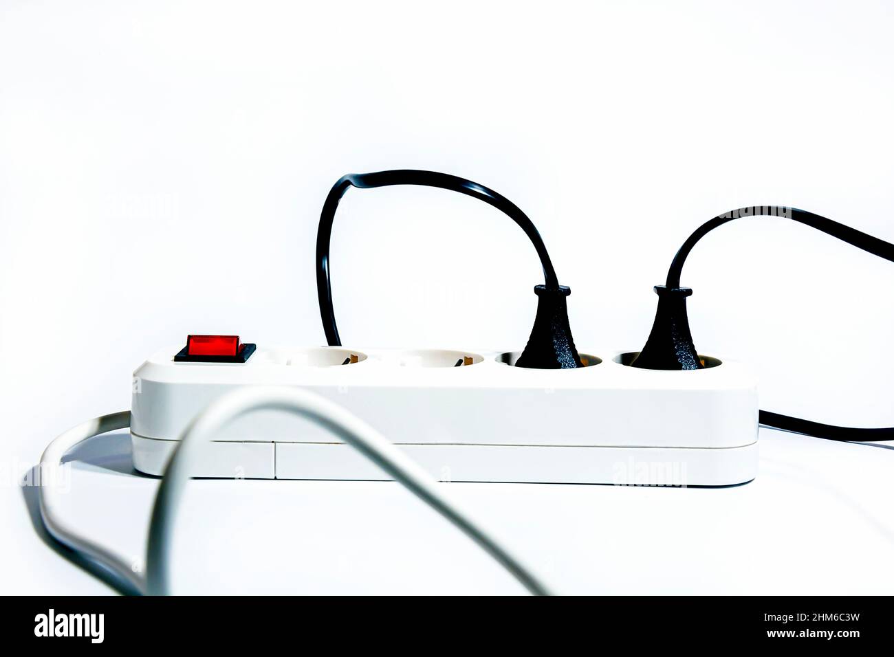 Extension cord with a red turned on button and inserted plugs and wires