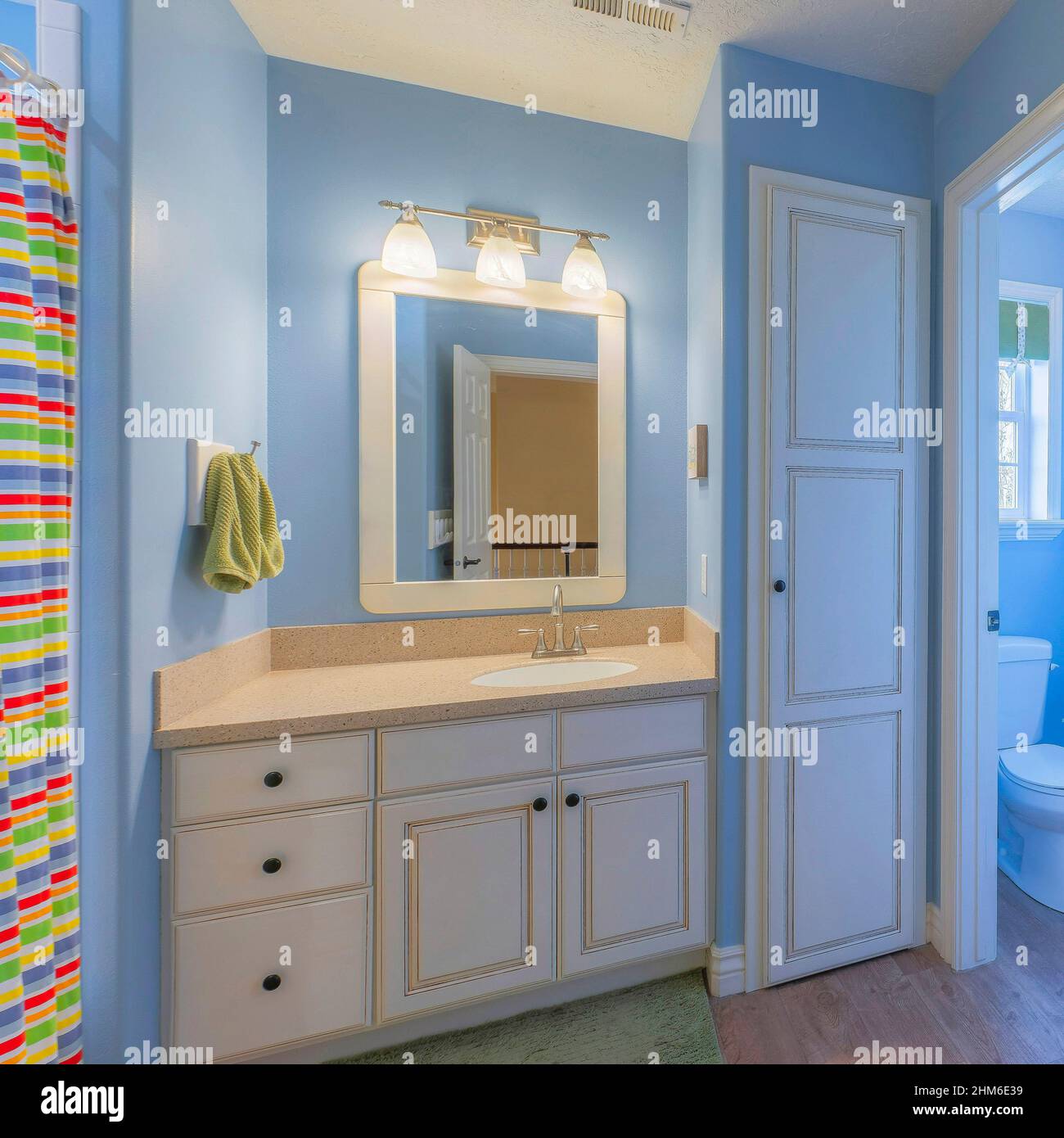 Square Master bathroom with light blue interior and two vanity sinks