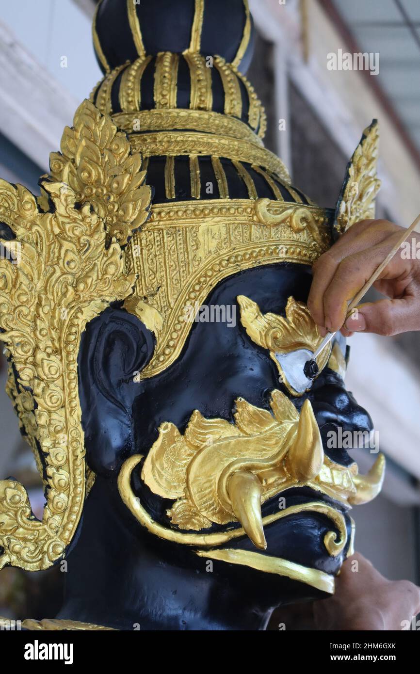 Painter puts final touch on a  statue in Bamrung Muang Road, Bangkok, Thailand Stock Photo
