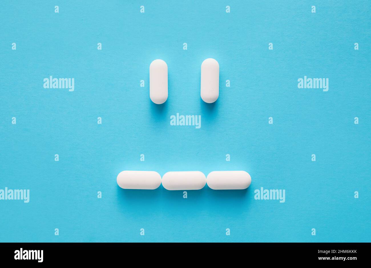 Sad face made of pills on color background Stock Photo - Alamy