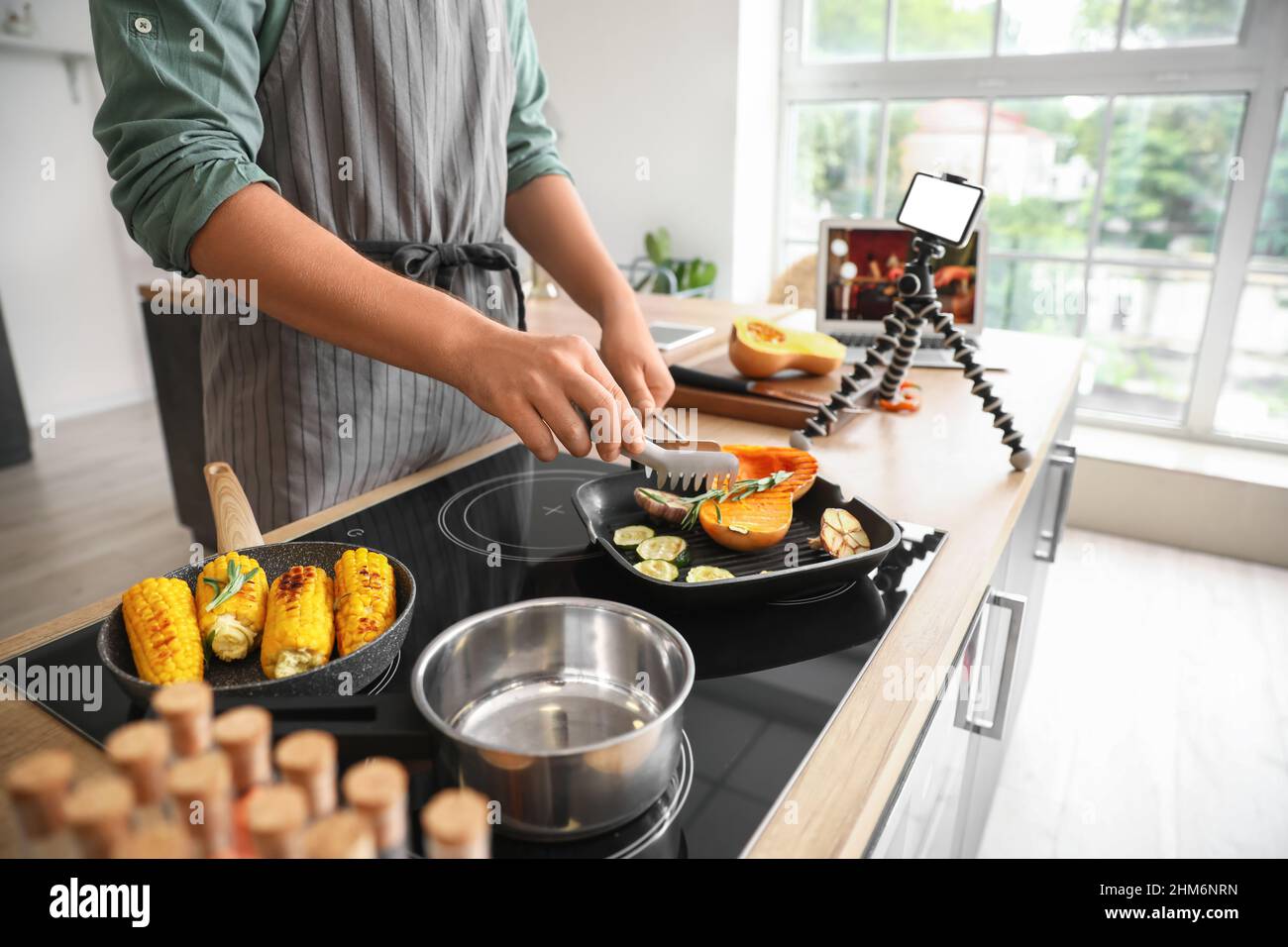 Young man cooking vegetables from video tutorial in kitchen Stock Photo ...