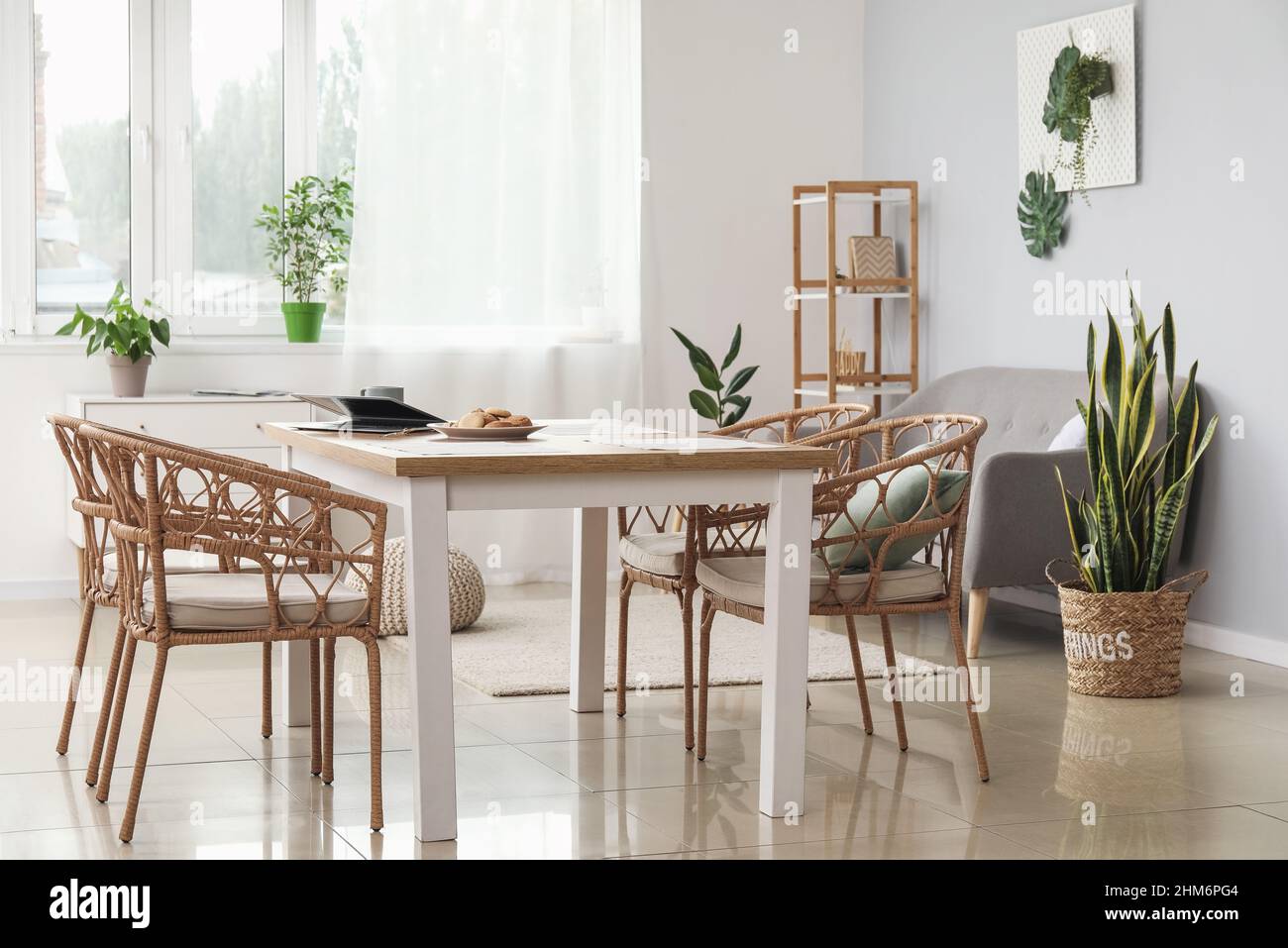 Interior of stylish room with dining table, sofa and houseplants Stock ...