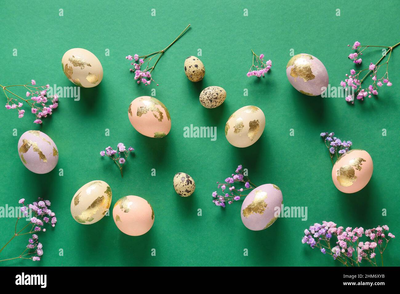 Different Easter eggs and gypsophila flowers on green background Stock ...