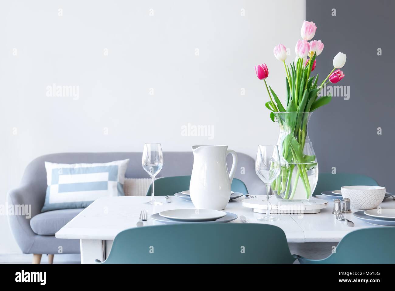 Dining table with stylish setting and vase with tulips Stock Photo