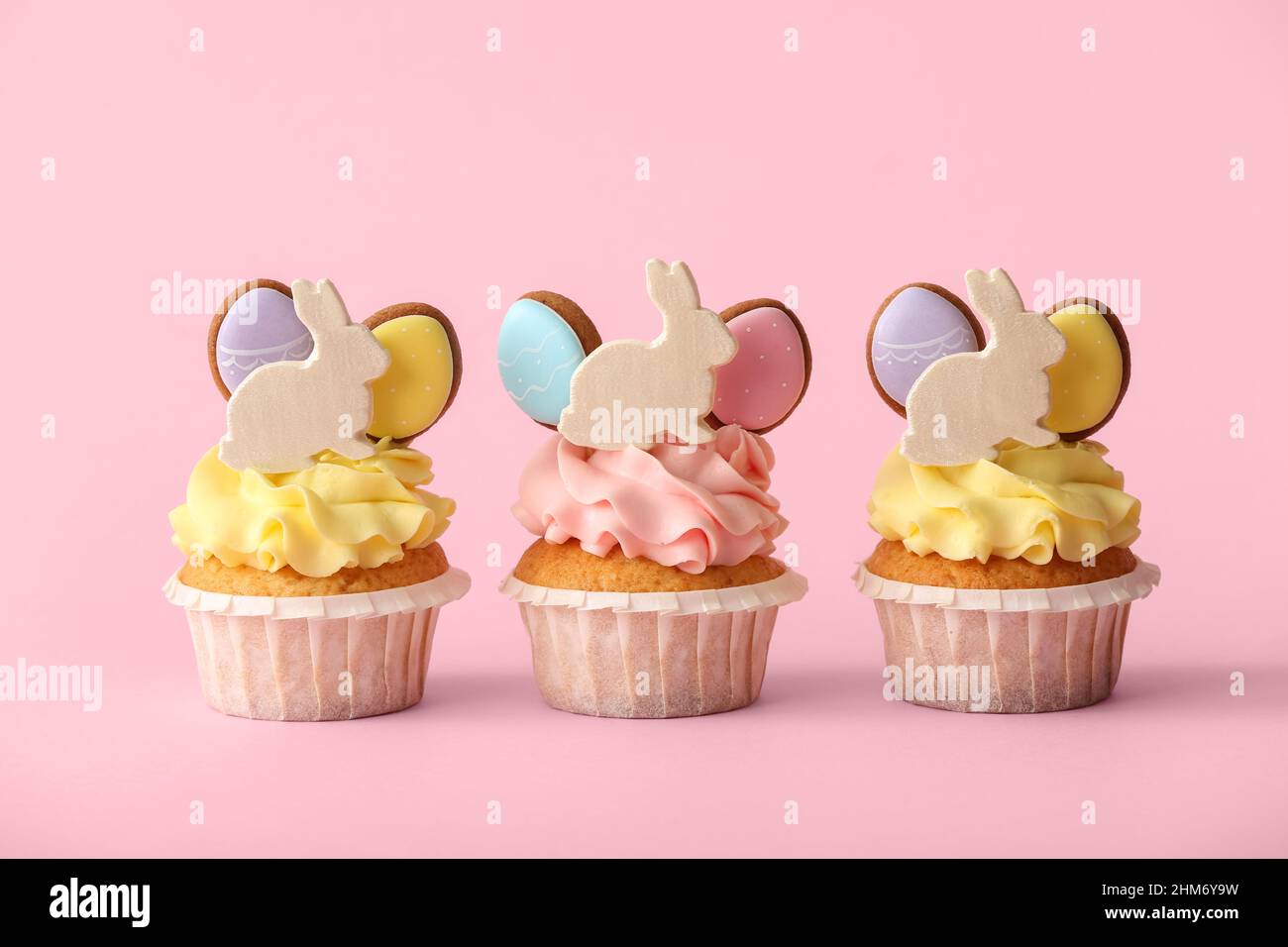 Tasty Easter cupcakes on pink background Stock Photo