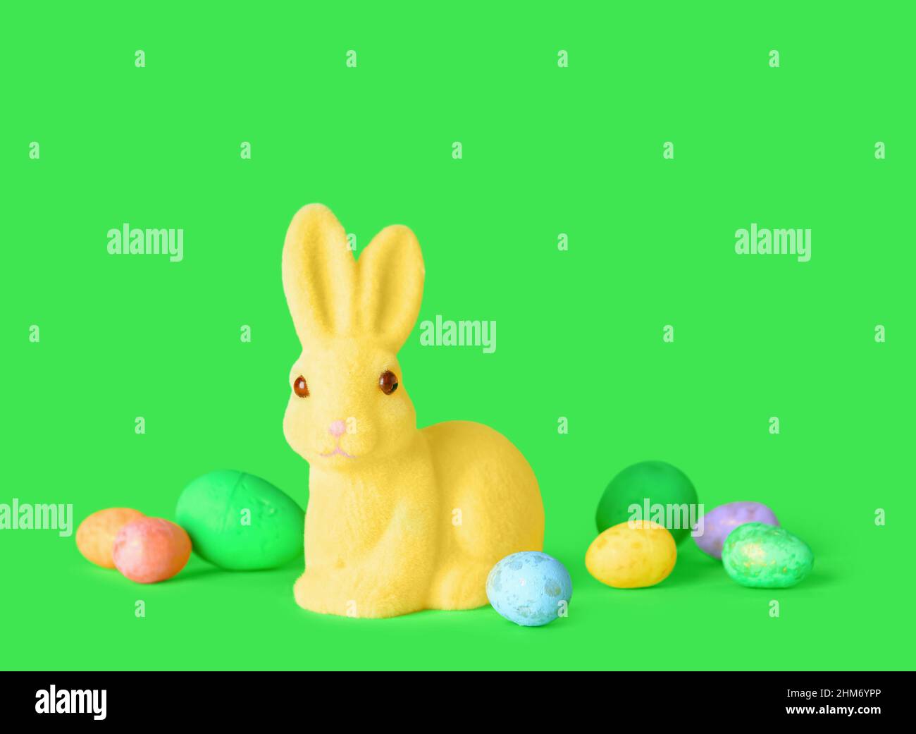 Cute Easter bunny and eggs on green background Stock Photo - Alamy