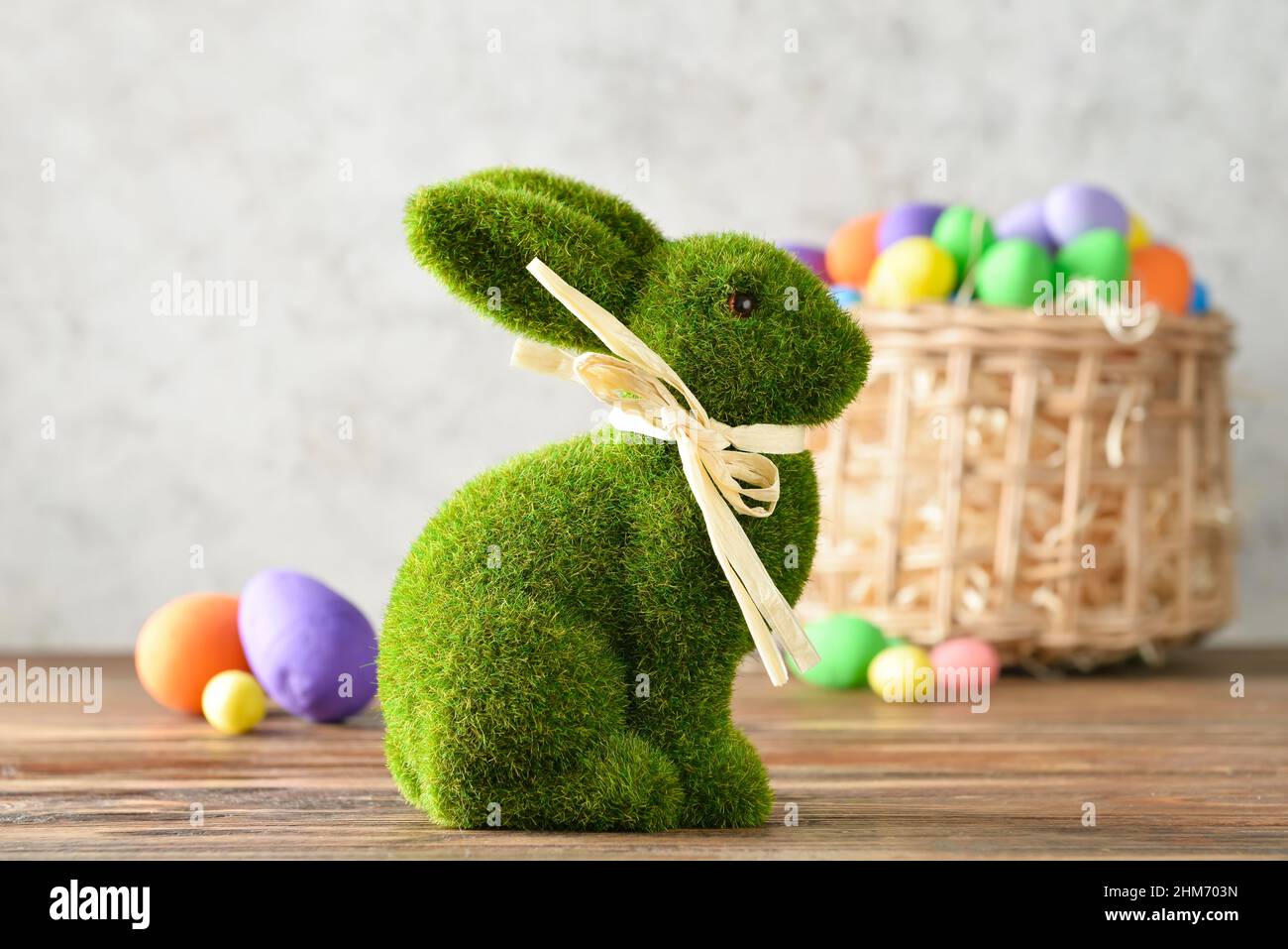 Easter bunny and wicker basket with painted eggs on grunge background ...