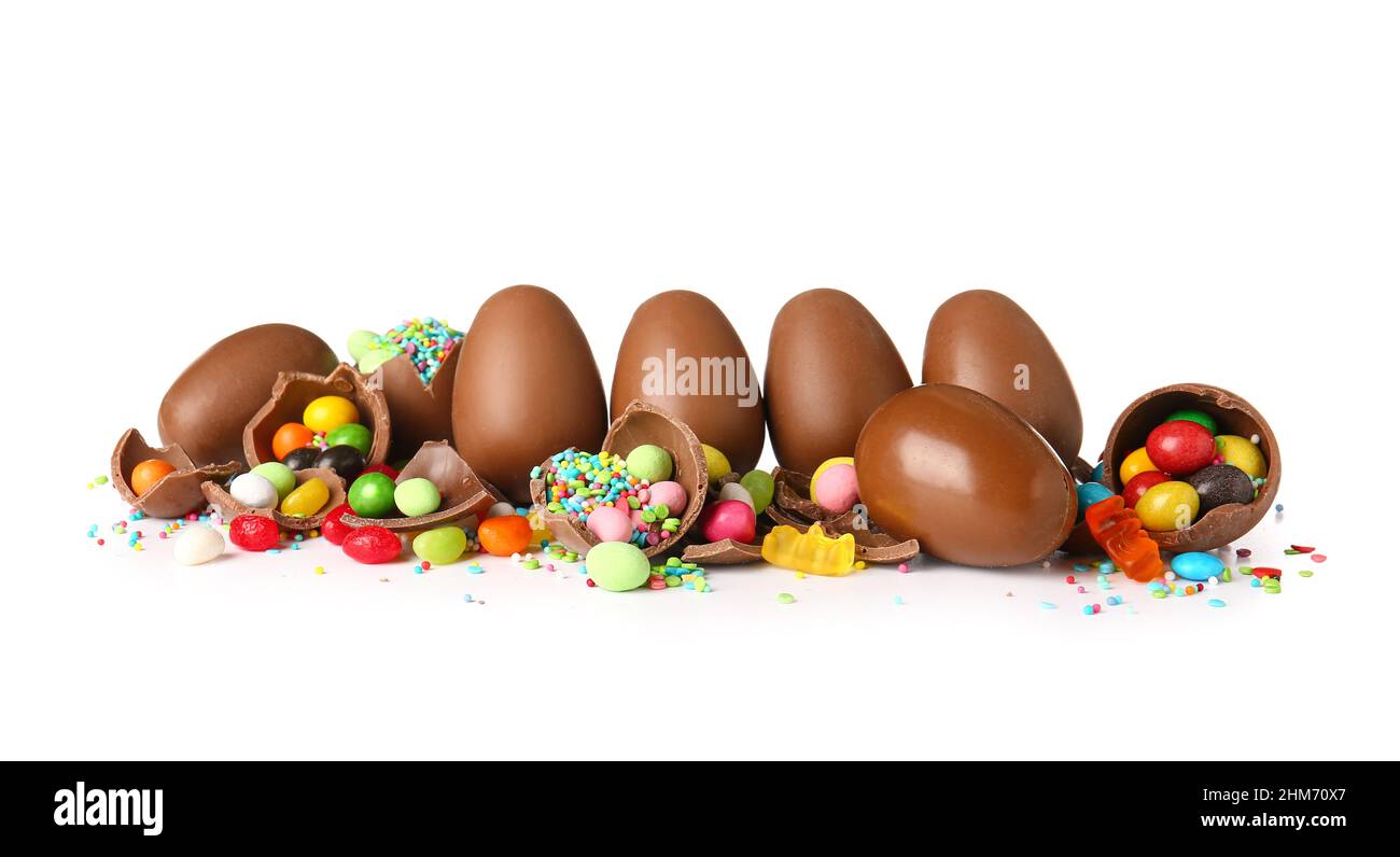 Delicious chocolate Easter eggs with different candies on white background Stock Photo