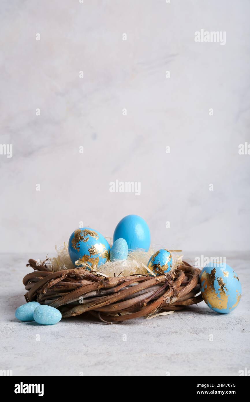 Nest with beautiful blue Easter eggs on light background Stock Photo ...