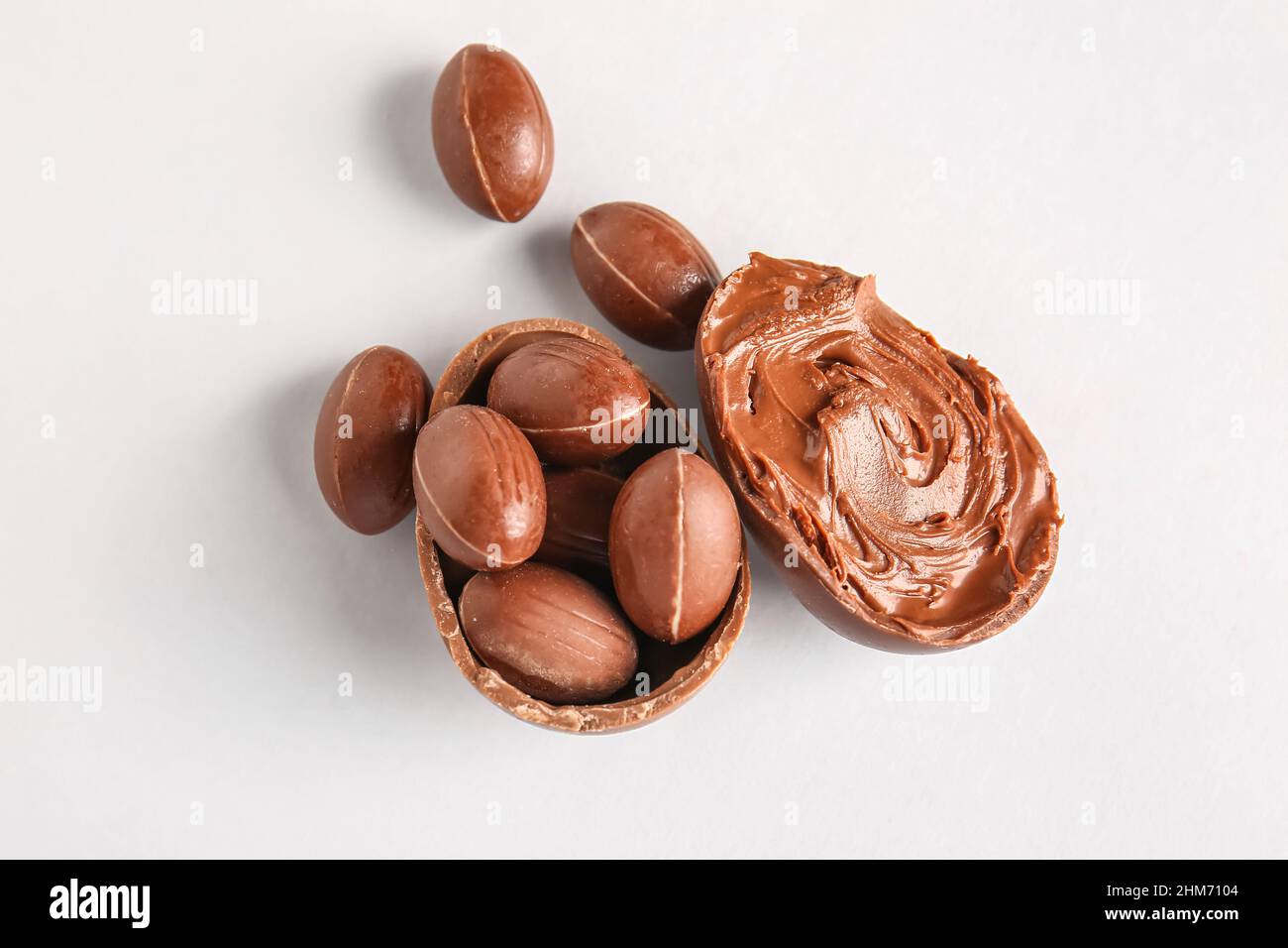 Different delicious Easter eggs with chocolate paste on light background Stock Photo