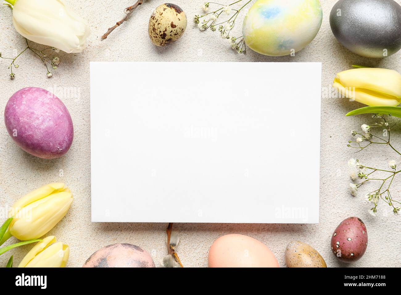 Composition with sheet of paper, Easter eggs and flowers on light ...
