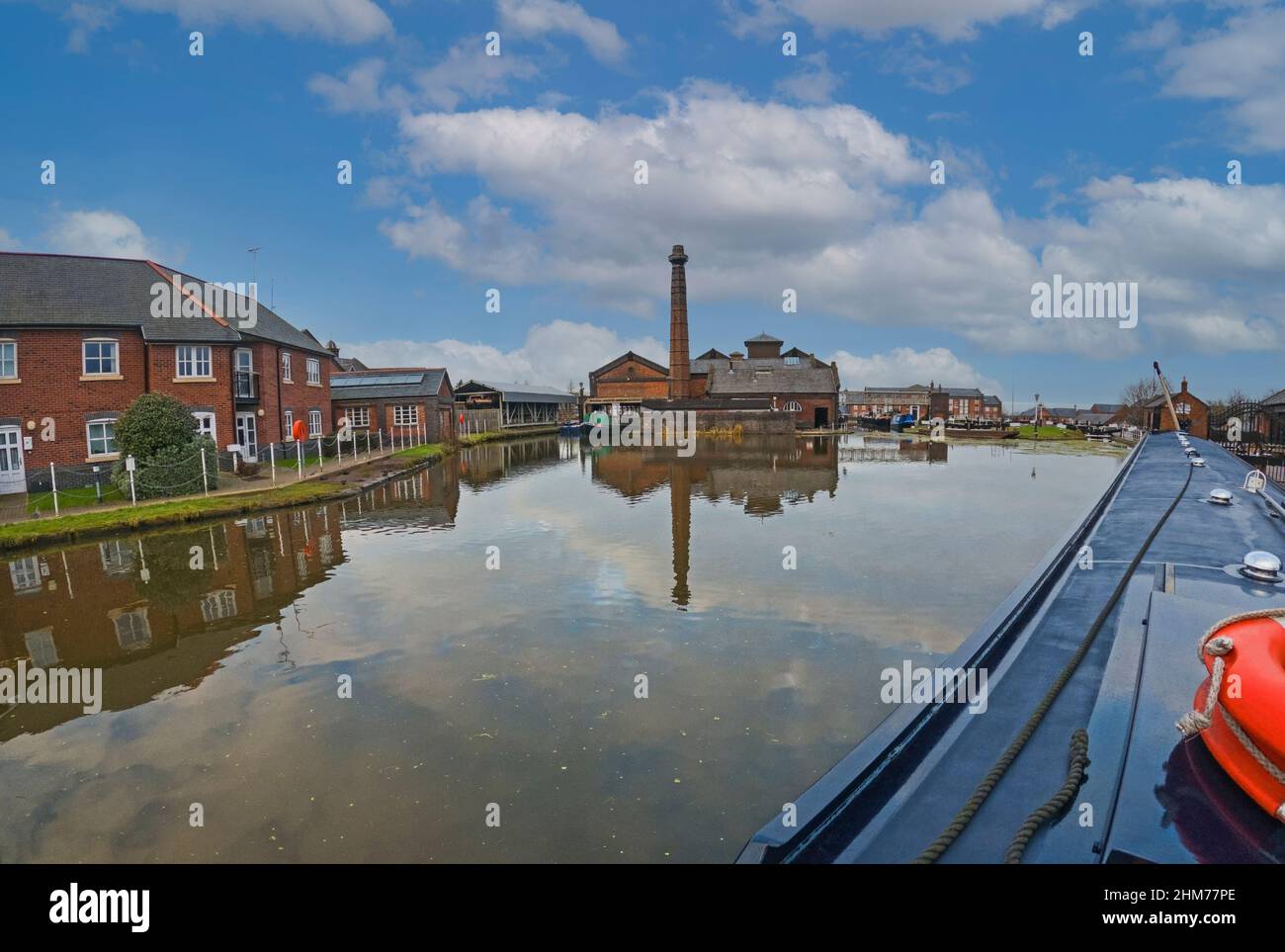 View from narrowboat traveling through English urban scenery on British canal with luxury waterfront real estate property in marina basin Stock Photo