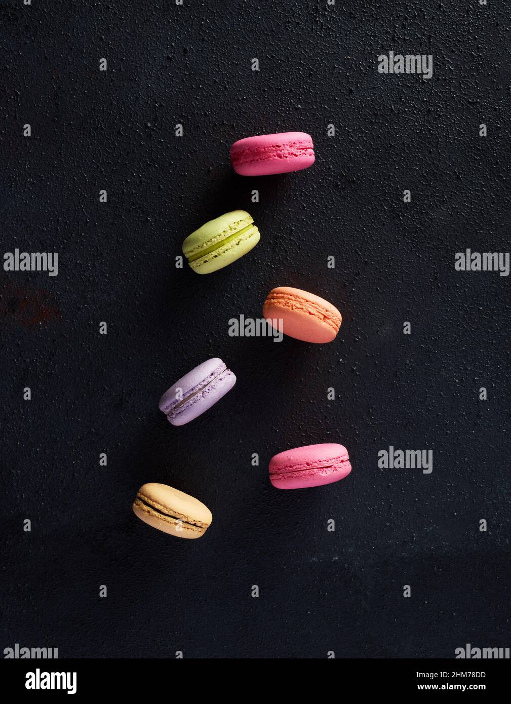 Colorful assorted macarons or macaroons on black background. Stock Photo