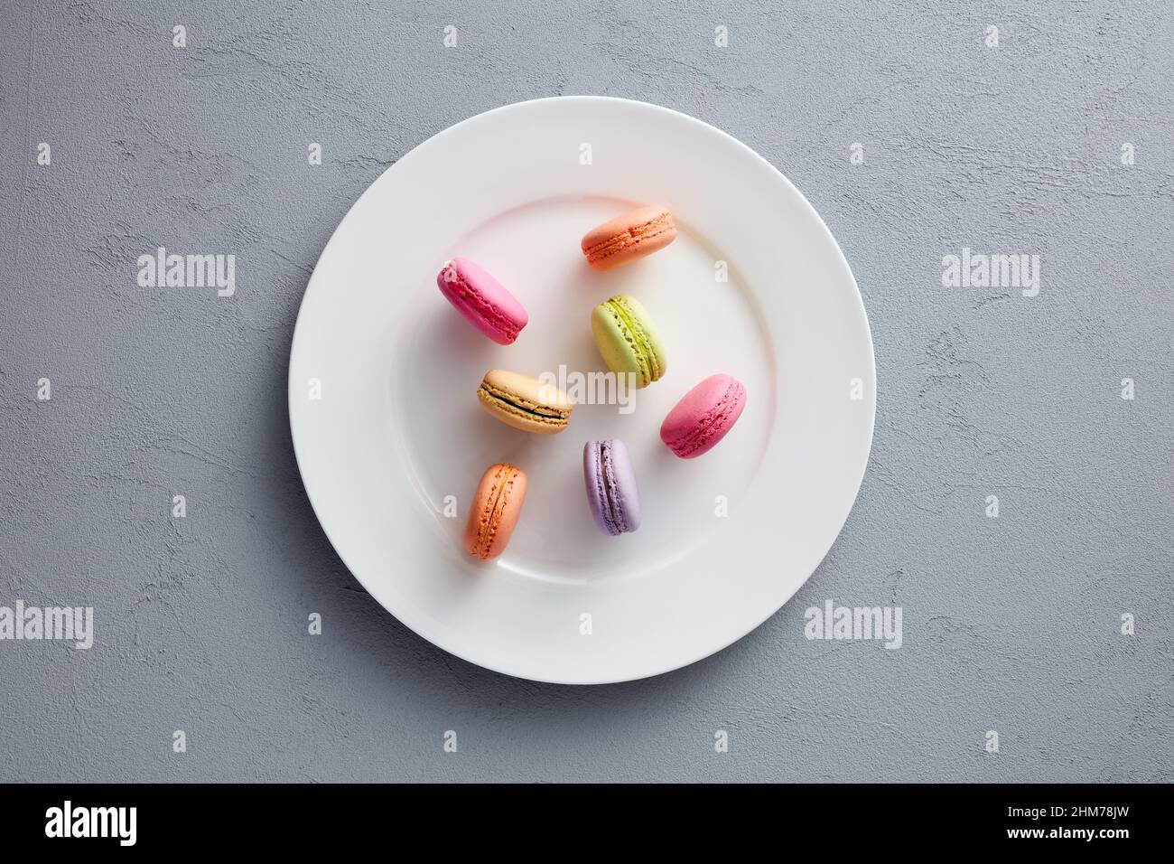 Colorful assorted macarons or macaroons on white dish. Stock Photo