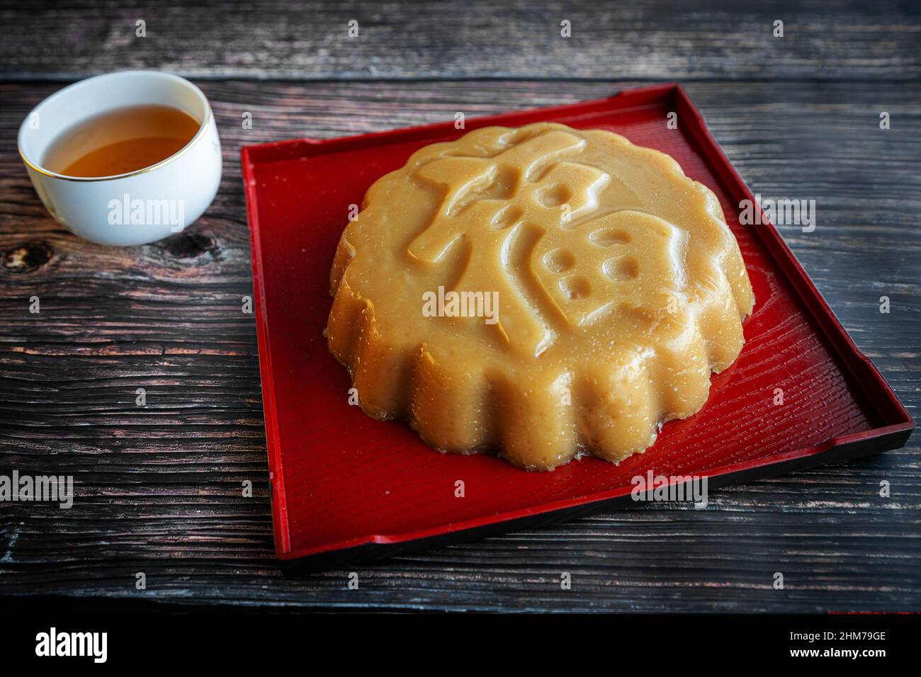 Traditional Chinese New Year sweet rice cake dessert known as Nian Gao, which is made from steamed glutinous rice flour batter. Rice cake with Chinese Stock Photo