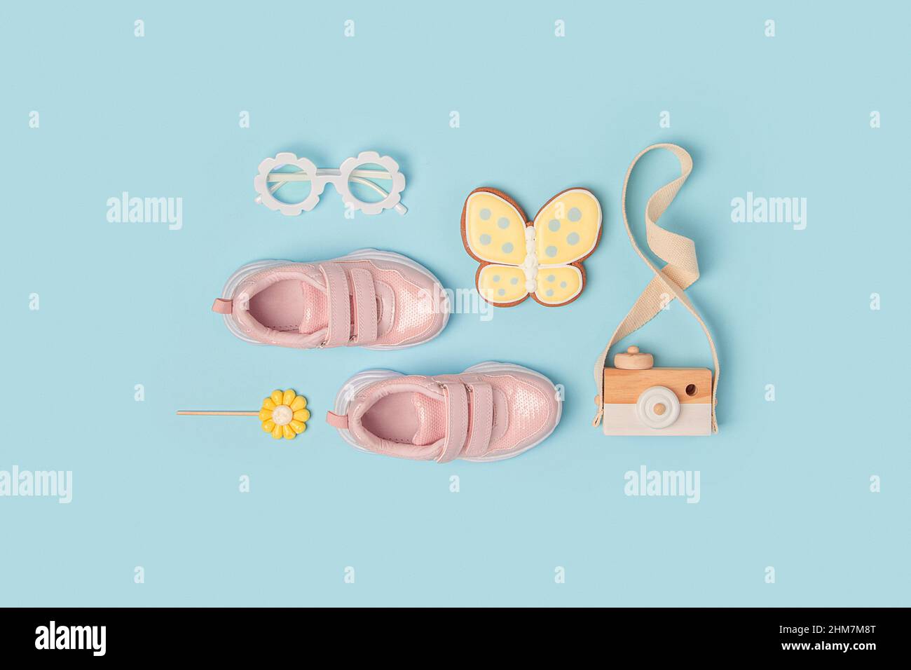 Sports shoes, pink sneakers, sunglasses and butterfly on background. Summer time, childhood and holiday concept. Top view Flat lay. Stock Photo