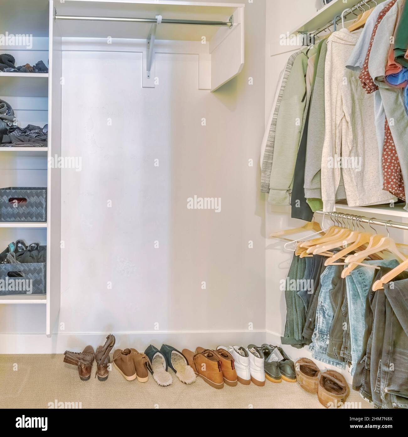 Square Walk in closet interior with hanging clothes and shoes on the floor Stock Photo
