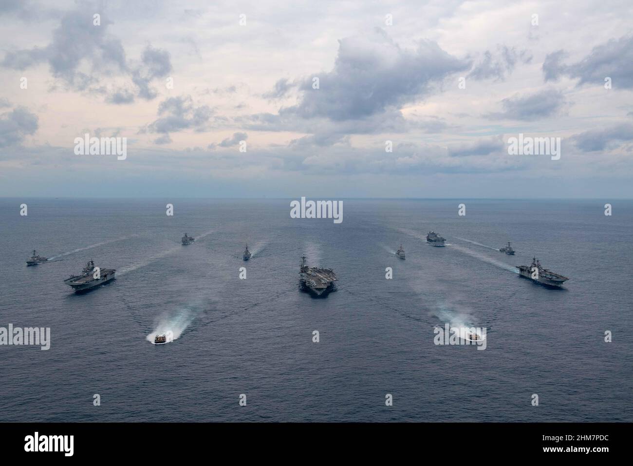 PHILIPPINE SEA (Feb. 7, 2022) Ships of the America and Essex Amphibious Ready Groups, and Carrier Strike Group (CSG) 3, sail in formation with the Japan Maritime Self-Defense Force during exercise Noble Fusion. Front row: Landing craft, air cushion from Assault Craft Unit (ACU) 5. Second row, left to right: USS America (LHA 6), USS Abraham Lincoln (CVN 72), USS Essex (LHD 2). Third row, left to right: USS Dewey (DDG 105), JS Kongō (DDG 173), USS Mobile Bay (CG 53), USS Spruance (DDG 111). Back row, left to right: USS Ashland (LSD 48), USS Miguel Keith (ESB 5). Noble Fusion demonstrates that Na Stock Photo