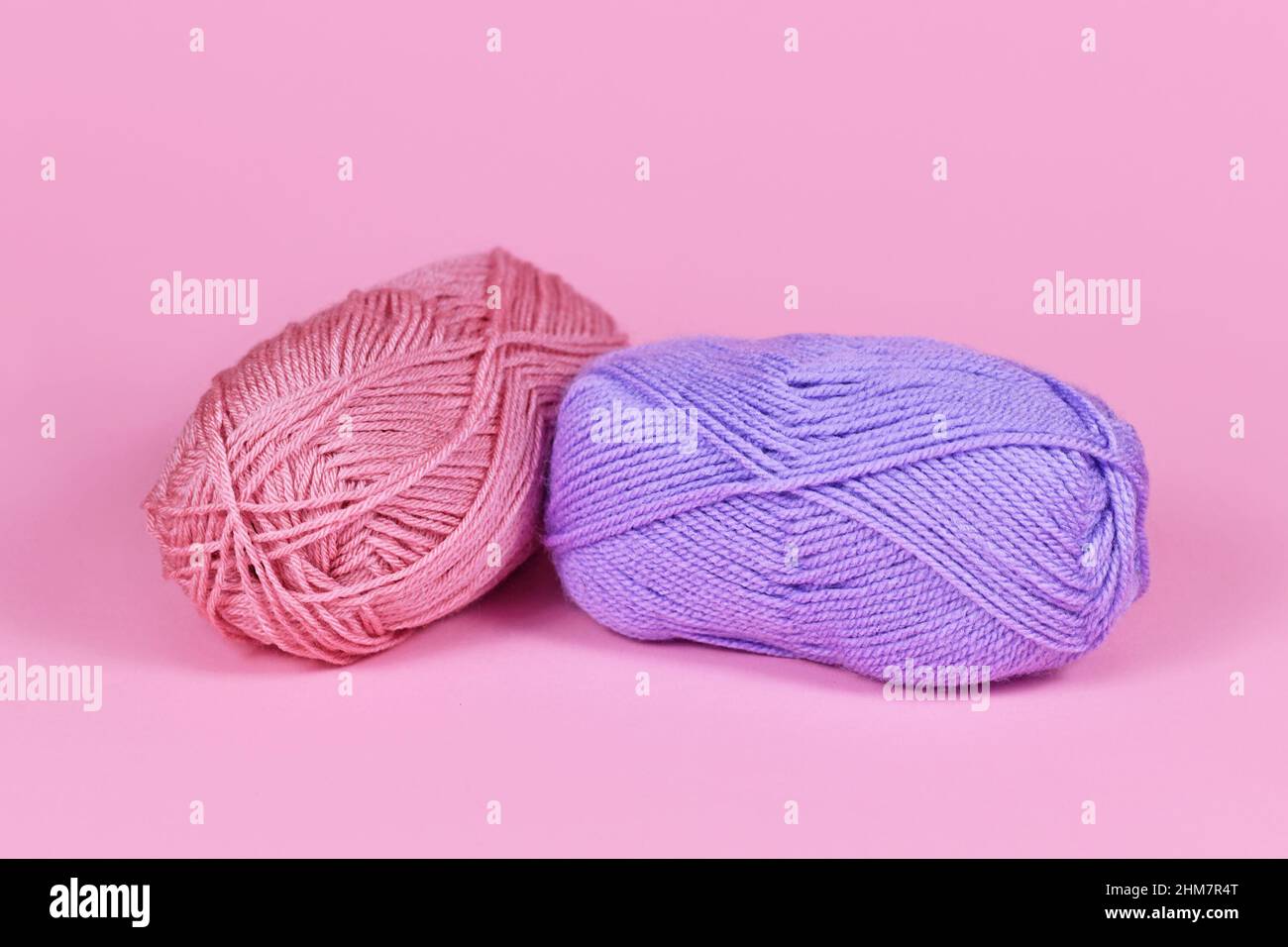 Two balls of wool on pink background Stock Photo