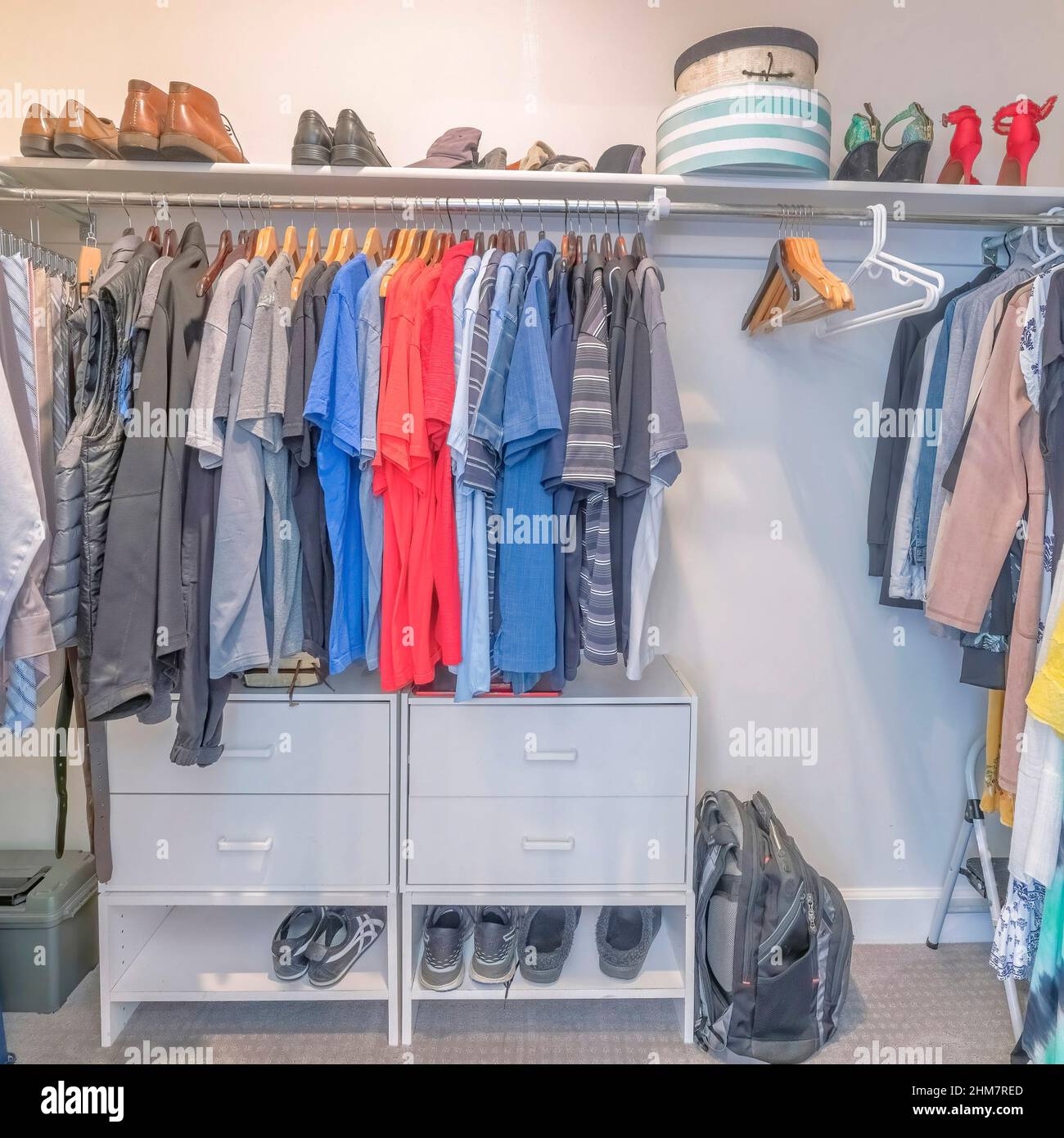 Square Interior of a windowless walk in closet with clothes and shoes Stock Photo