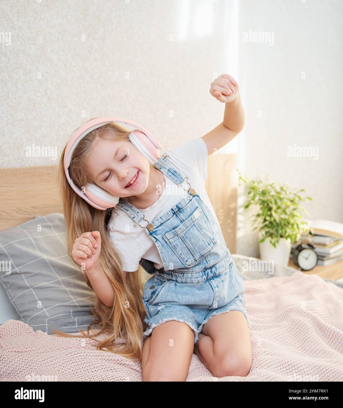 Adorable little girl in headphones enjoy with a music Stock Photo - Alamy
