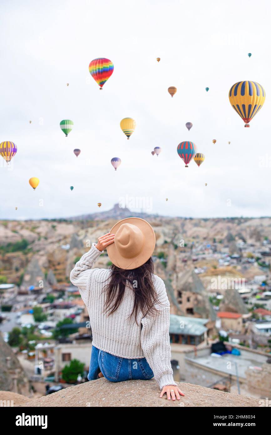 Happy woman in hat in Cappadocia. Woman with air balloons in the background  in the sky in Goreme in Cappadocia, Turkey Stock Photo - Alamy