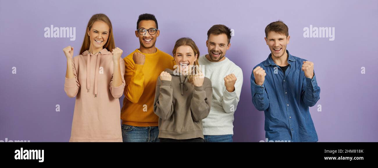 Young people expressing their excitement and delight by shouting Yes and clenching fists. Stock Photo