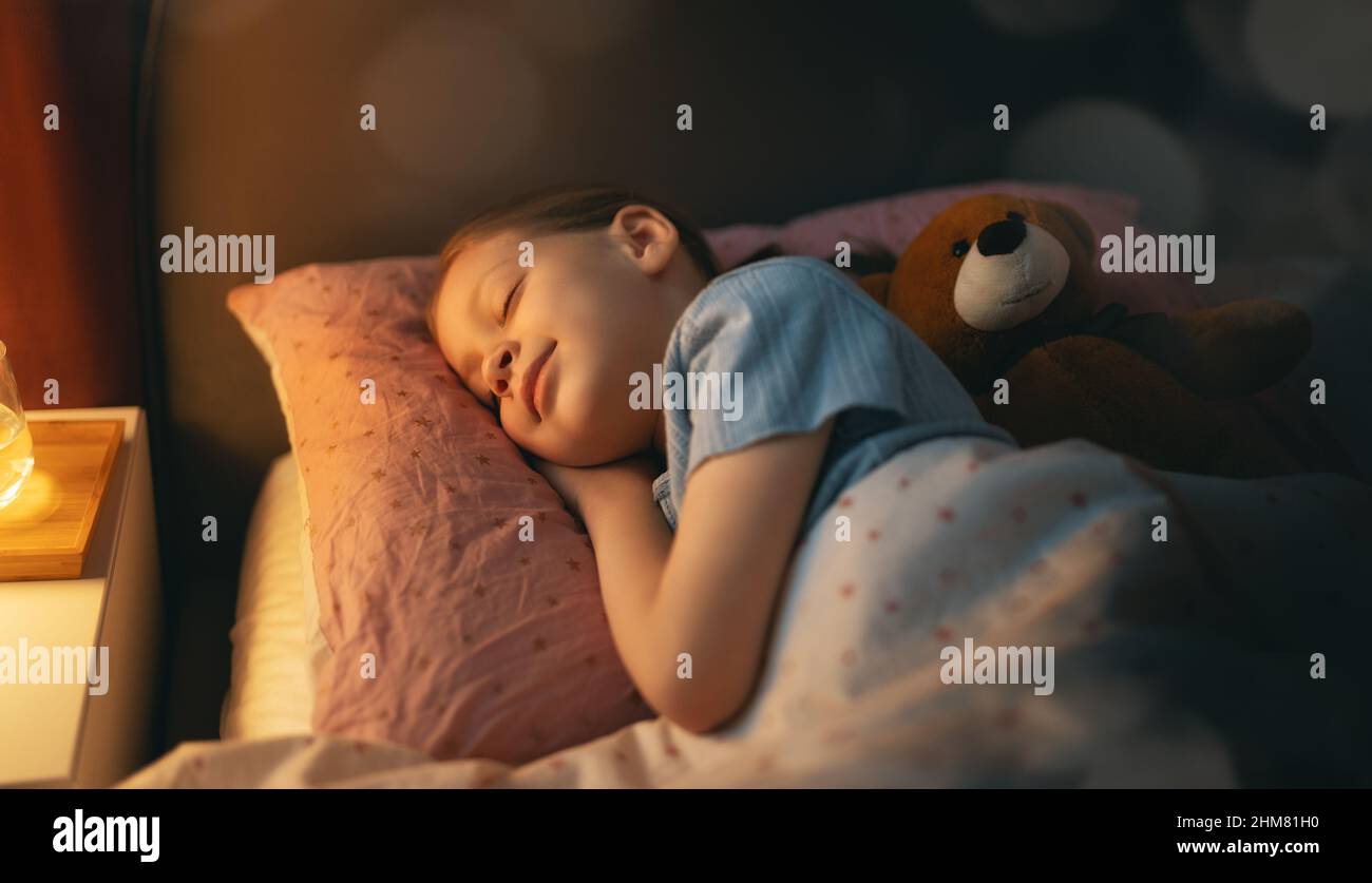 Adorable little child is sleeping in the bed Stock Photo - Alamy