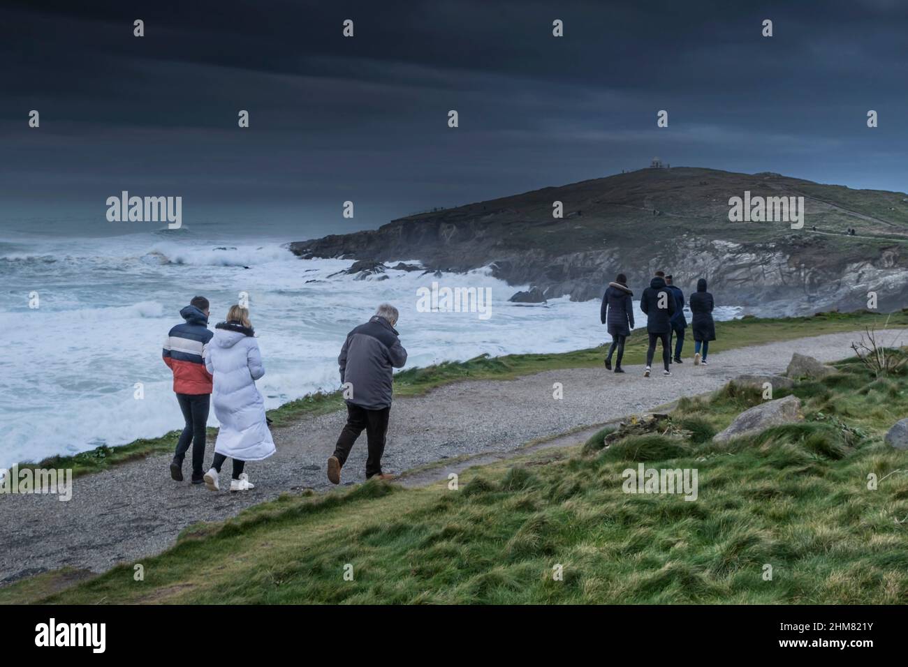 Visitors enjoying a brisk walk along the coast path to Towan Head in Newquay in Cornwall. Stock Photo