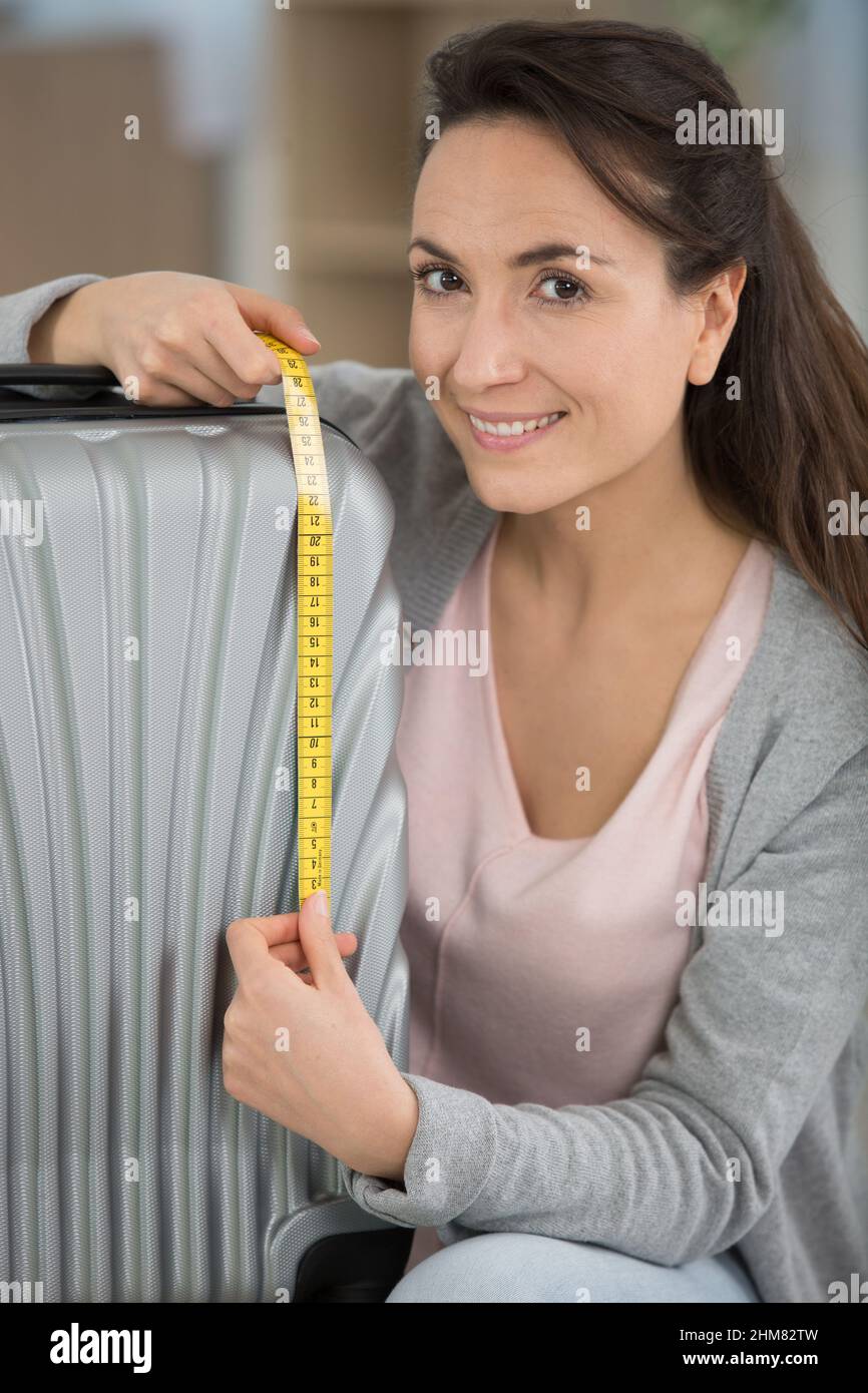 woman checking her luggage measurments before vacation Stock Photo