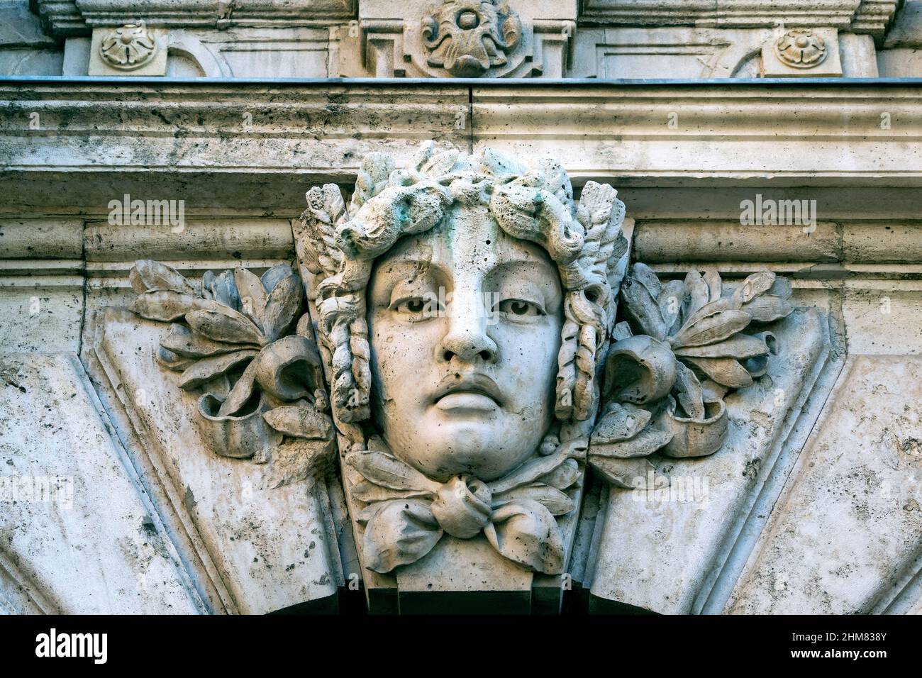 Close-up of a stone human face as decor or Mascaron on building facade Stock Photo