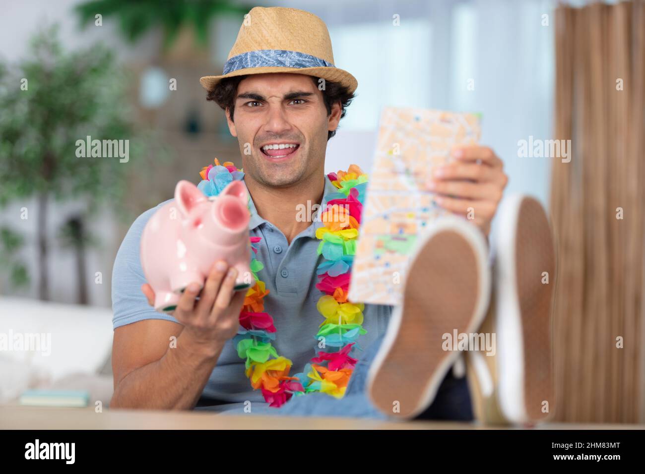 man putting coin into piggy bank about travelling Stock Photo - Alamy