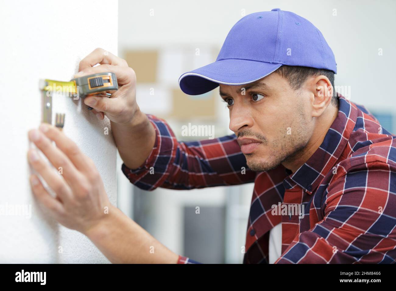 construction worker measuring bracket in a new house Stock Photo