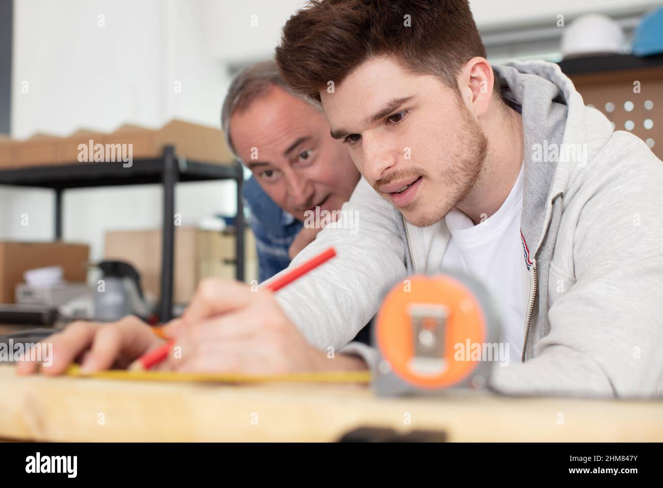 teacher and young man writing with pencil Stock Photo - Alamy