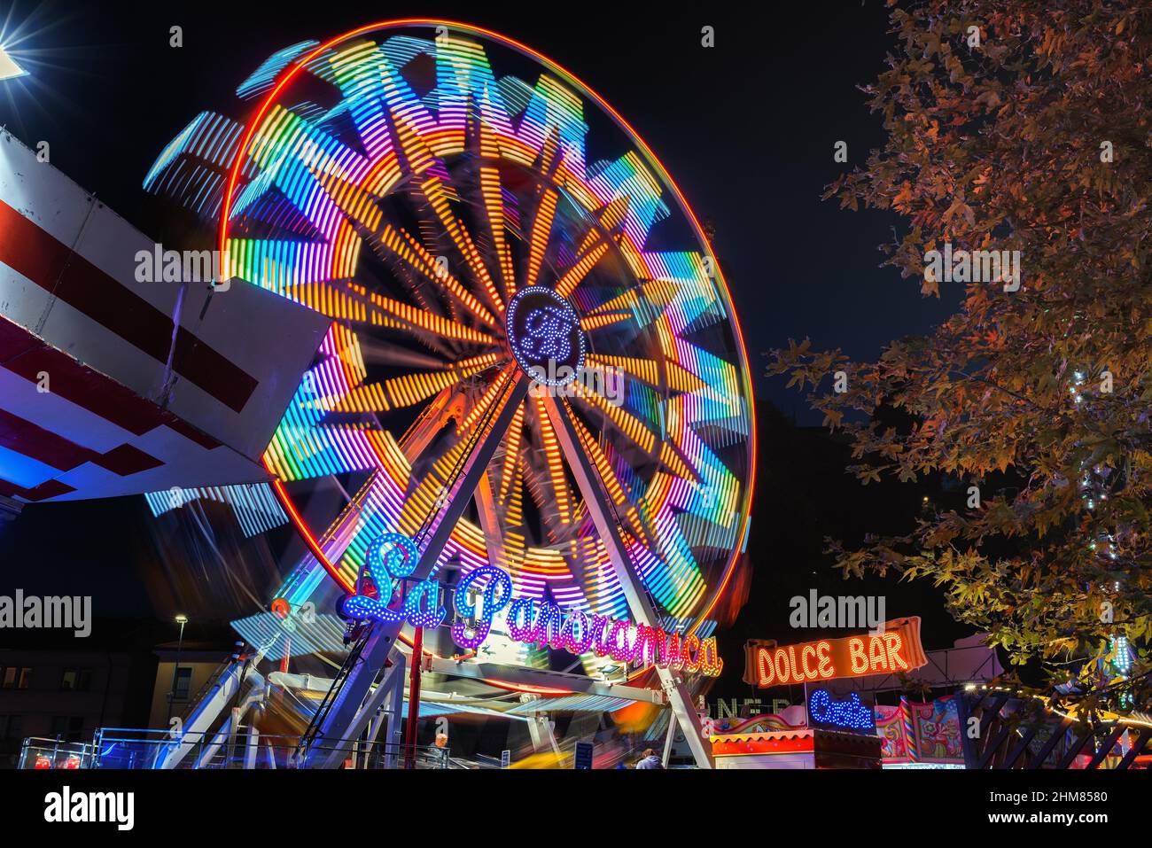 Panoramic wheel running in the dark. Luna park attraction. Long exposure photography. Stock Photo
