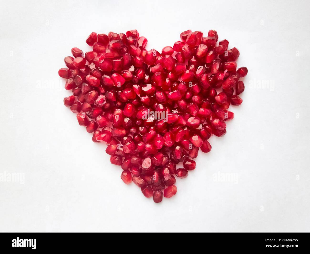 Heart from pomegranate seeds isolated on white background. Heart shape. High quality photo Stock Photo