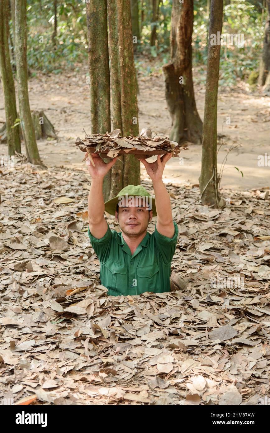 A tour guide reveals a hidden entrance to the network of tunnels at the