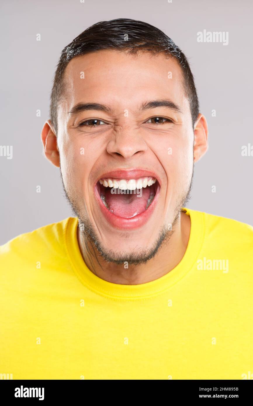 Screaming scream aggressive angry shouting young latin man latino people person Stock Photo