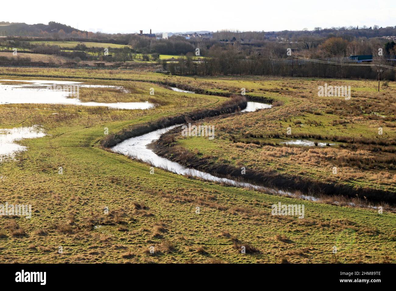 On a bright but cool and crisp winter morning the River Erewash flows down the valley towards Nottingham under The Iron Giant, the Bennerley viaduct. Stock Photo