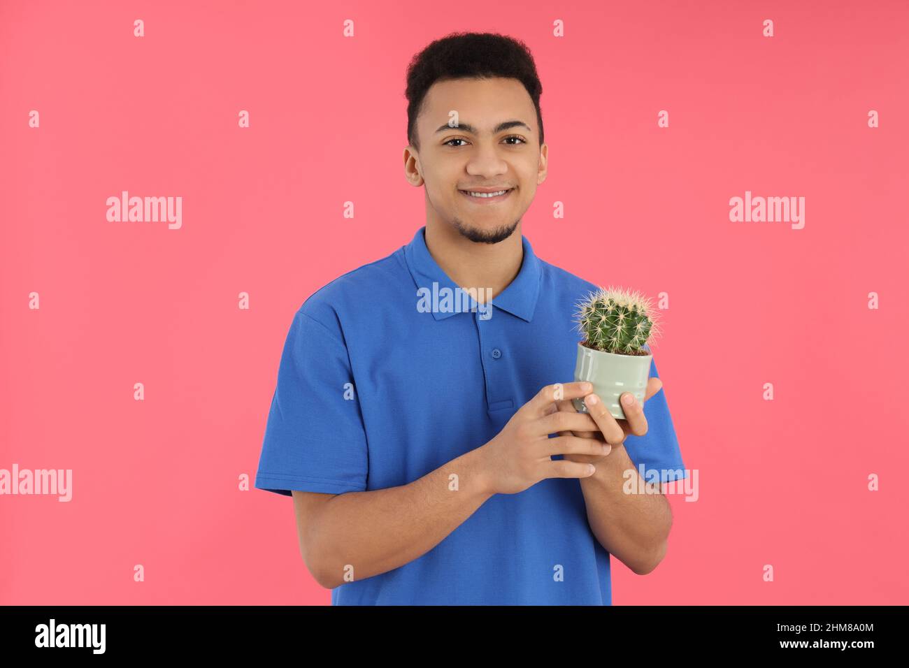 Young man with cactus on pink background Stock Photo
