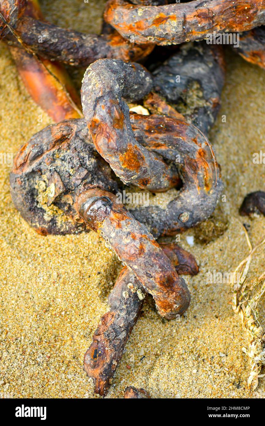 Rusty Chain on the beach still connected Stock Photo