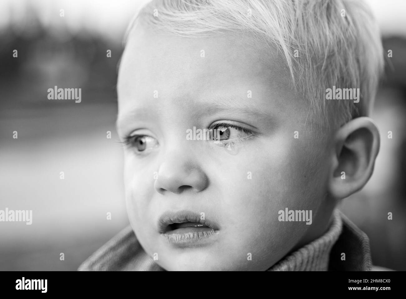 Little boy with tears close up defocused background. Emotional sad baby. Toddler sad face crying. Sad emotions. Hard to be toddler. Cute son crying Stock Photo