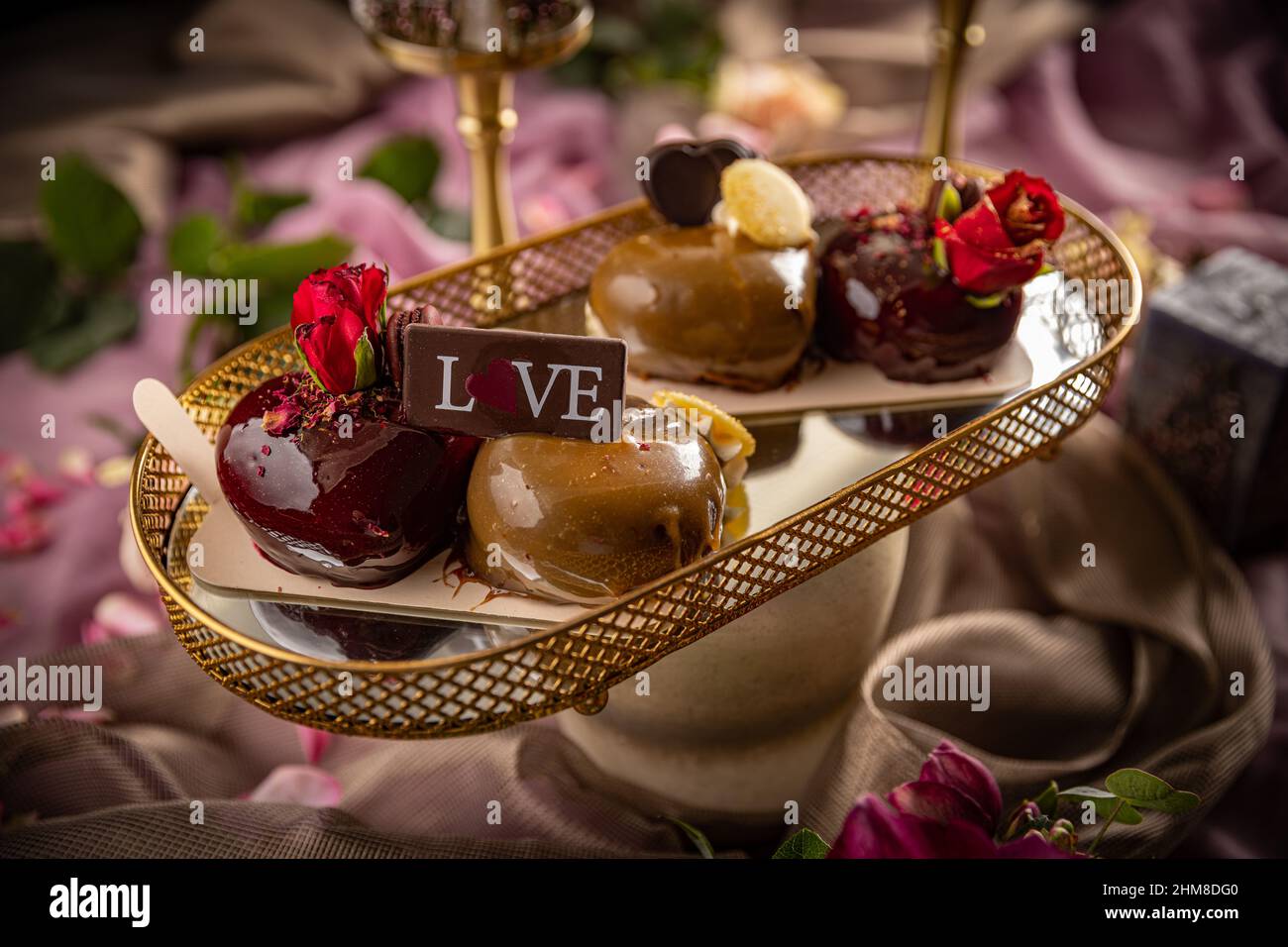 Still life of heart shaped mini cakes decorated with rose Stock Photo