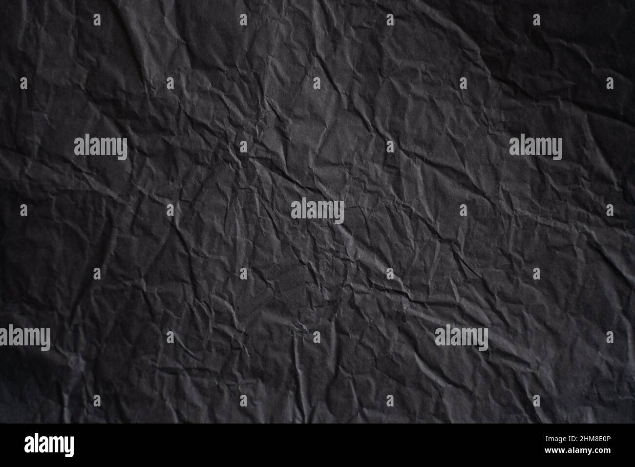 an empty wrinkled dark black tissue paper textured background Stock Photo