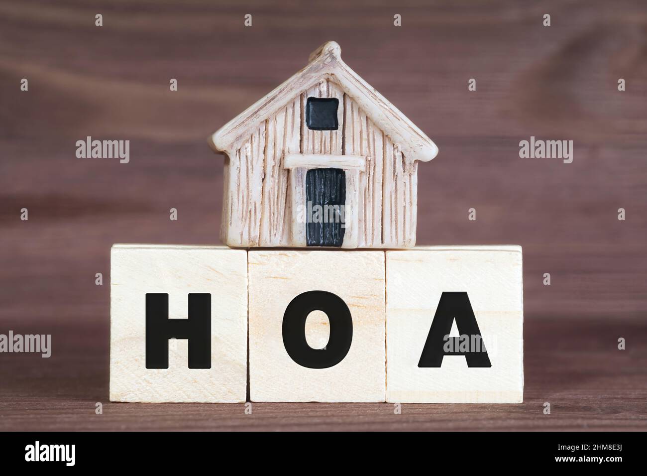Abbreviation HOA made from wooden letter blocks with a miniature house on top. Homeowner association concept. Stock Photo