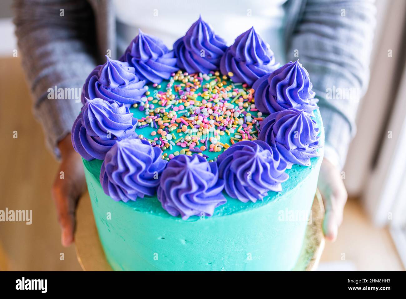 Birthday cake with turquoise buttercream and purple rosettes and