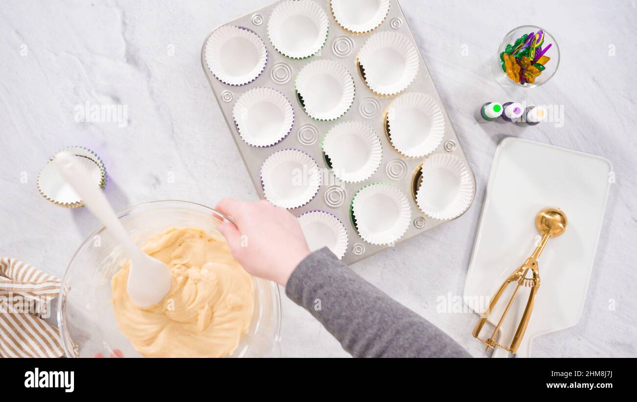 https://c8.alamy.com/comp/2HM8J7J/flat-lay-step-by-step-scooping-cupcake-batter-into-a-foil-cupcake-liners-to-bake-vanilla-mardi-gras-cupcakes-2HM8J7J.jpg