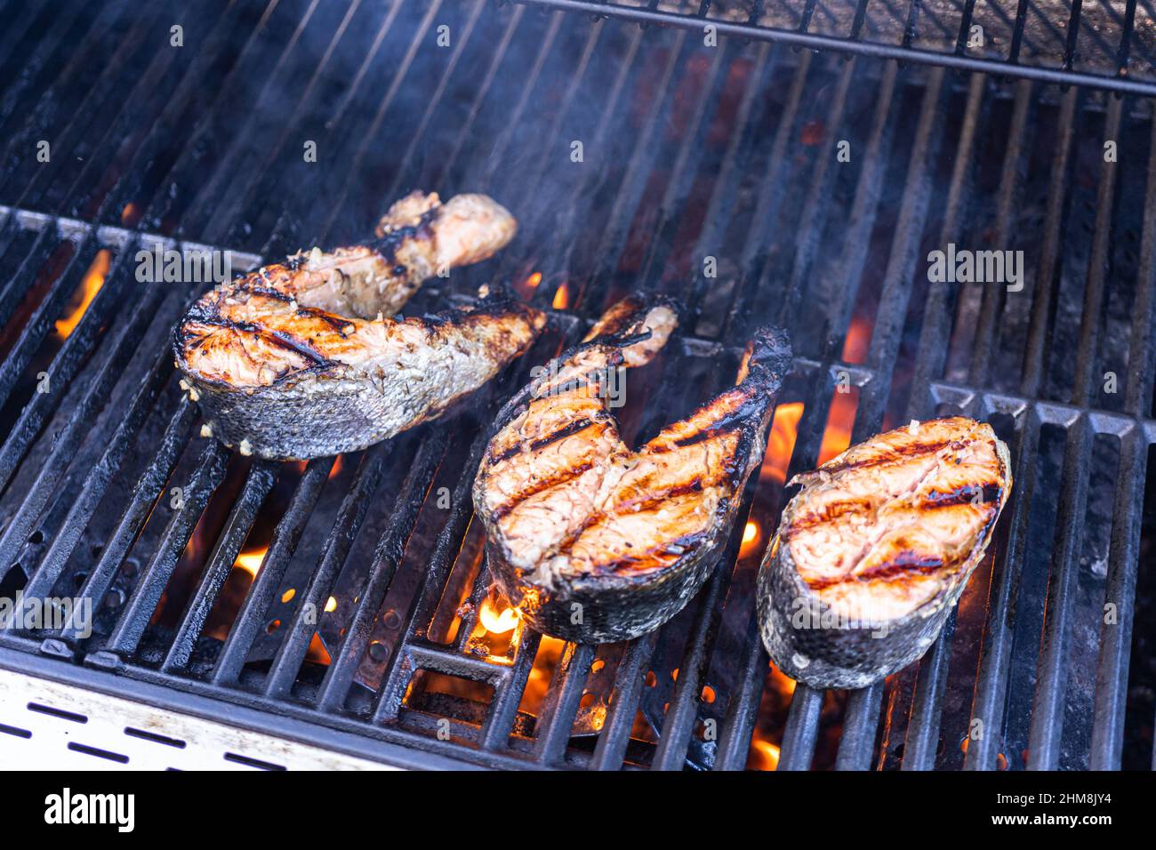 Grilling salmon steaks on an outdoor gas grill Stock Photo - Alamy