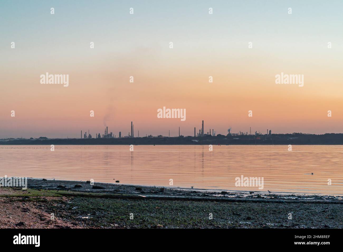 Fawley Oil Refinery during sunset as seen from Weston shore, Southampton, Hampshire, England, UK Stock Photo