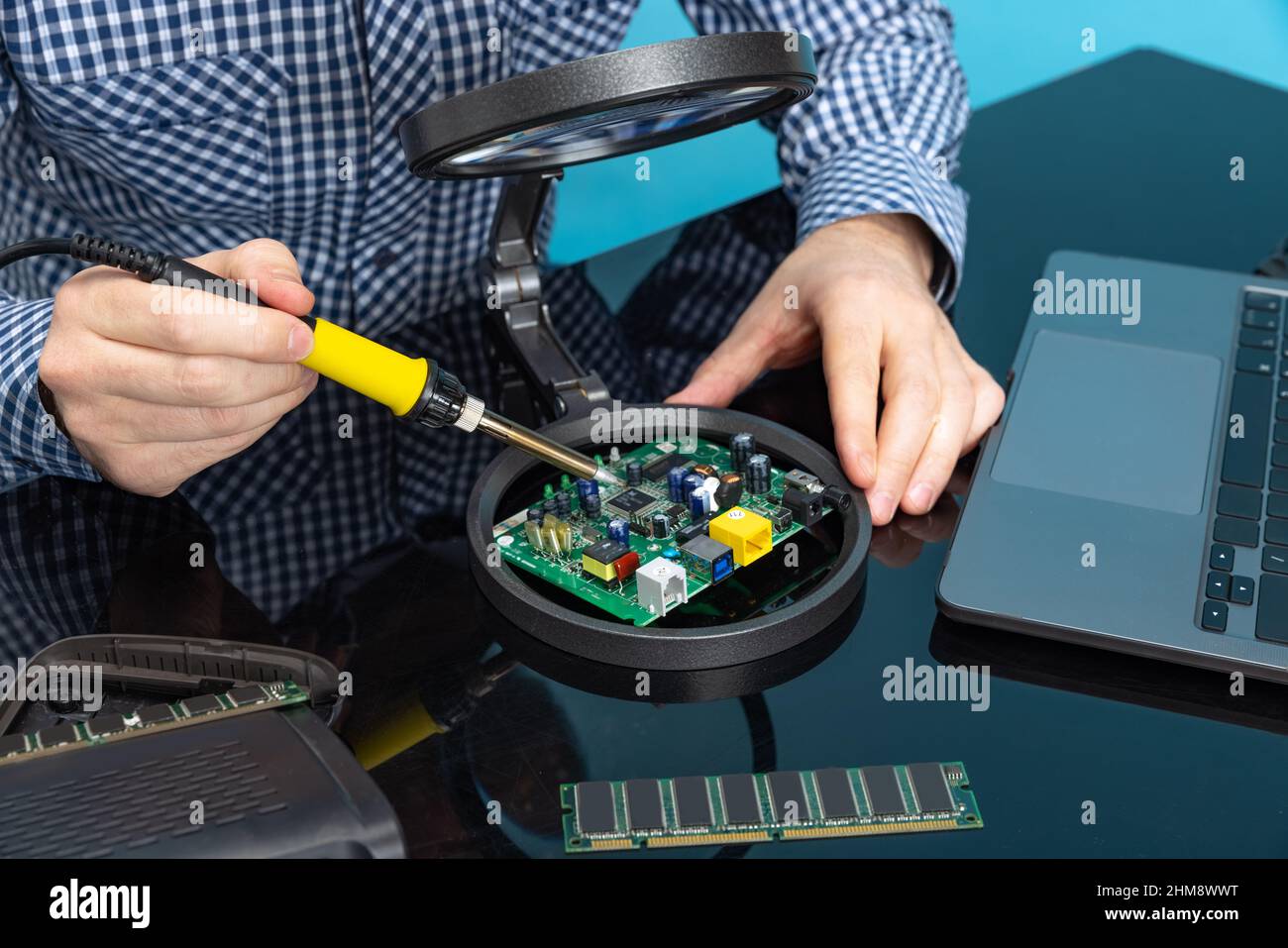 Cropped image of male hands working with motherboard isolated over blue ...
